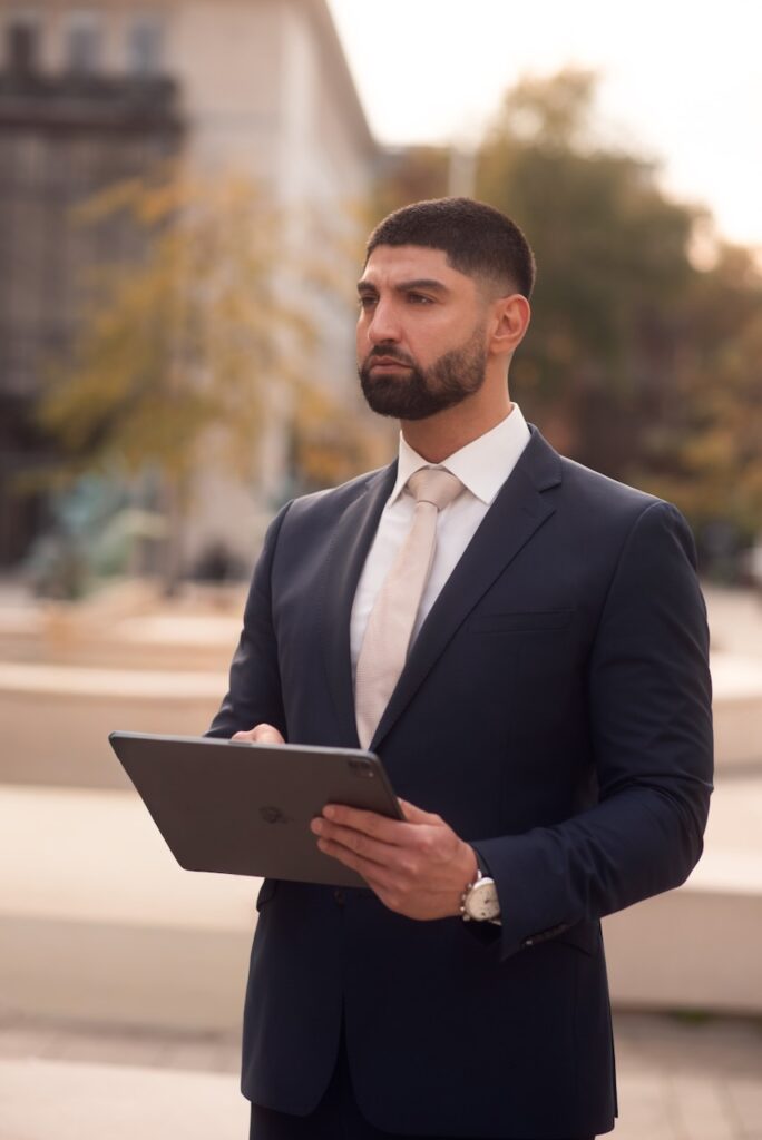 Businessporträt eines Mannes im dunklen Anzug vor einer modernen Fassade