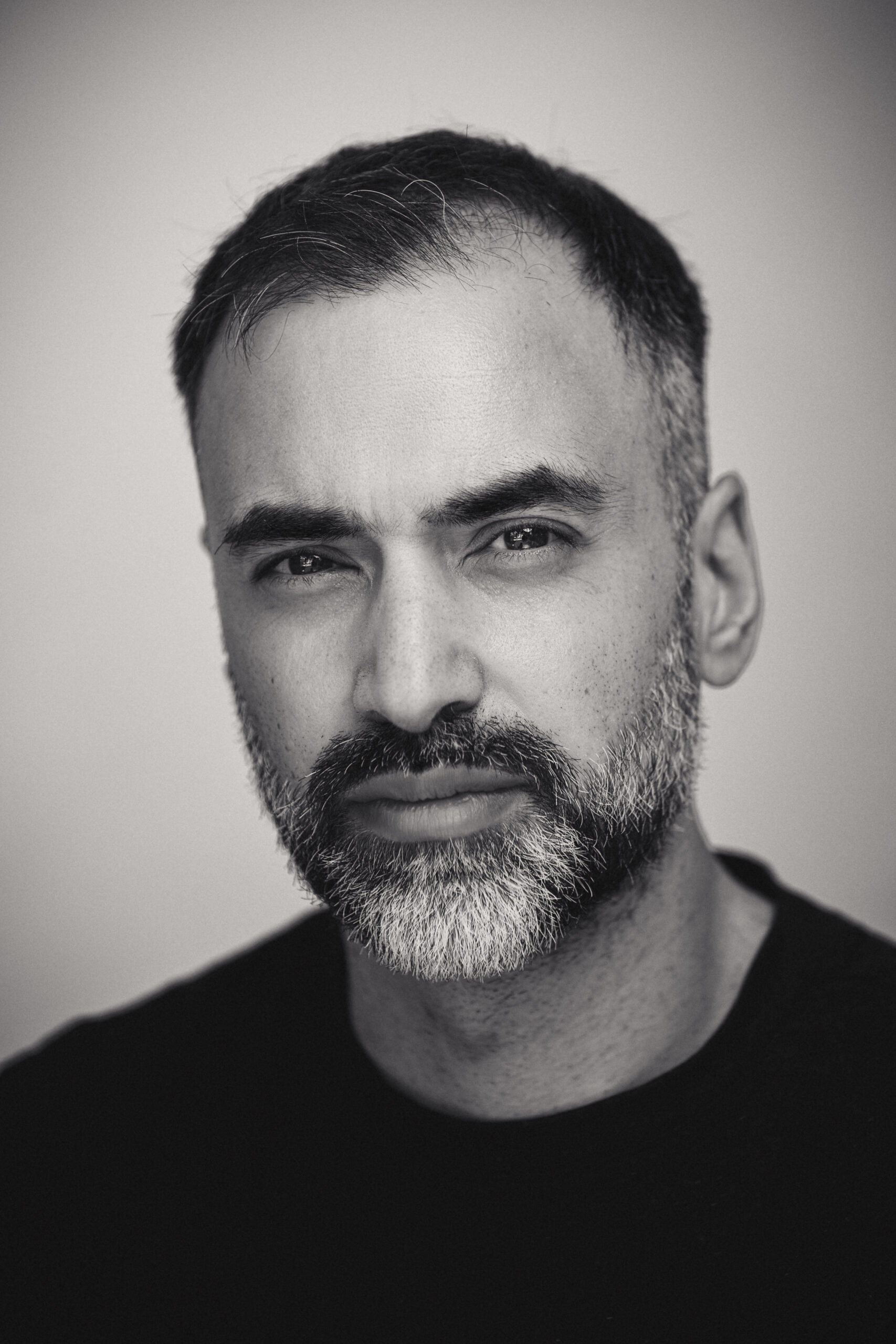 Schwarz-Weiß-Porträt des Fotografen Fahim Farooq mit kurzem Haar und Bart