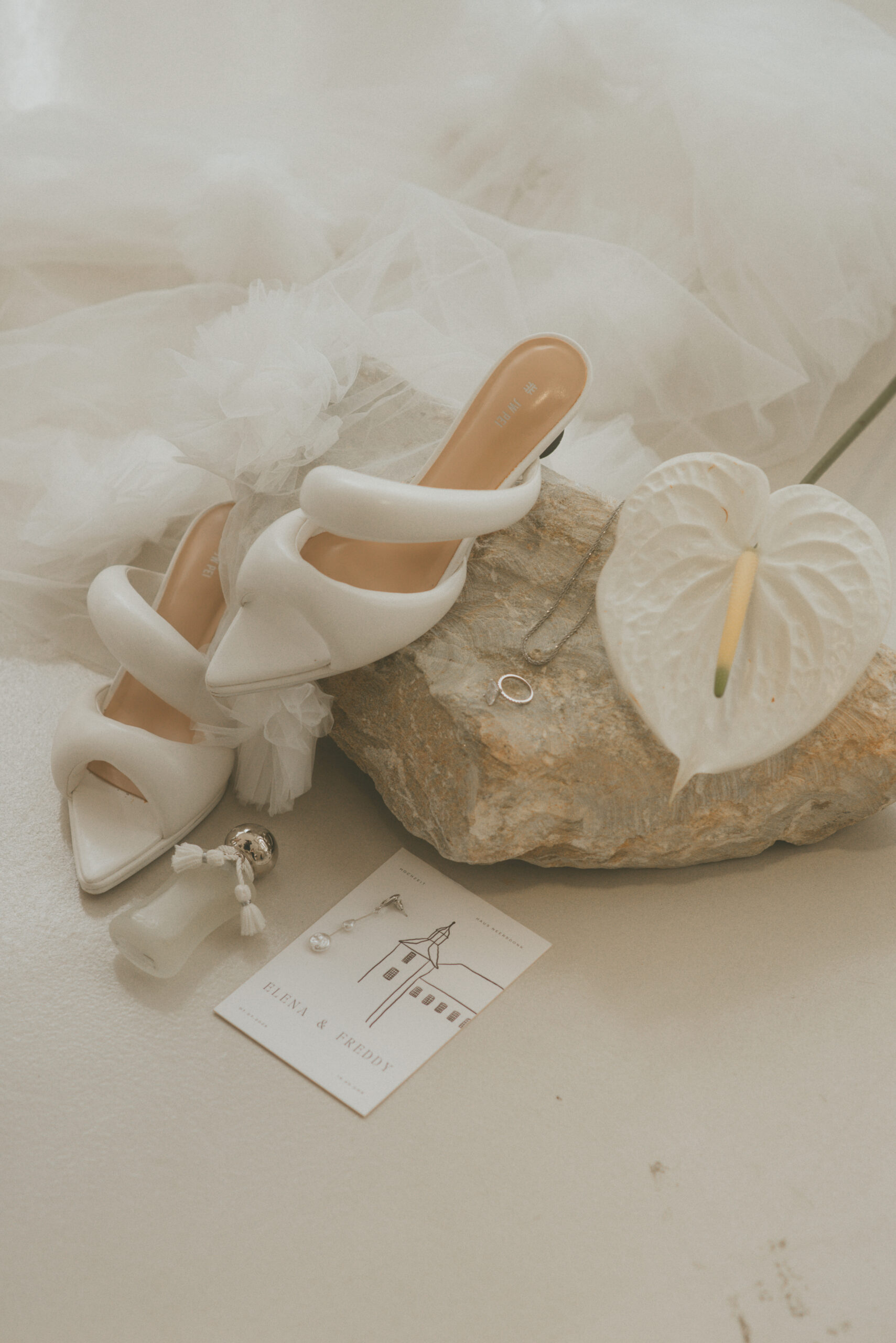 Weiße Brautschuhe und eine helle Handtasche als Hochzeitsdetails