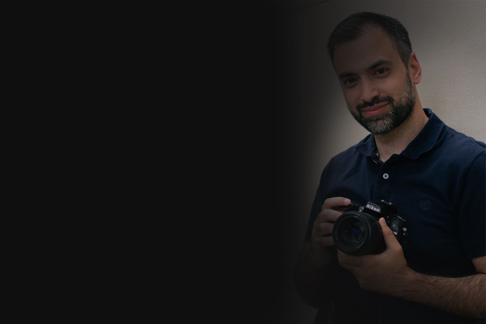 Fotograf Fahim Farooq mit einer Nikon-Kamera vor einer hellen Wand